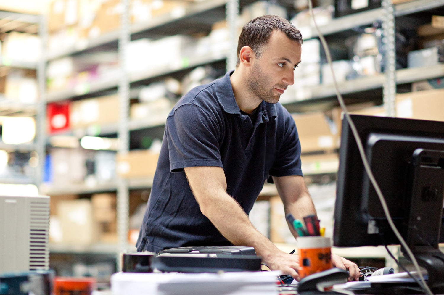 man in warehouse working at his computer