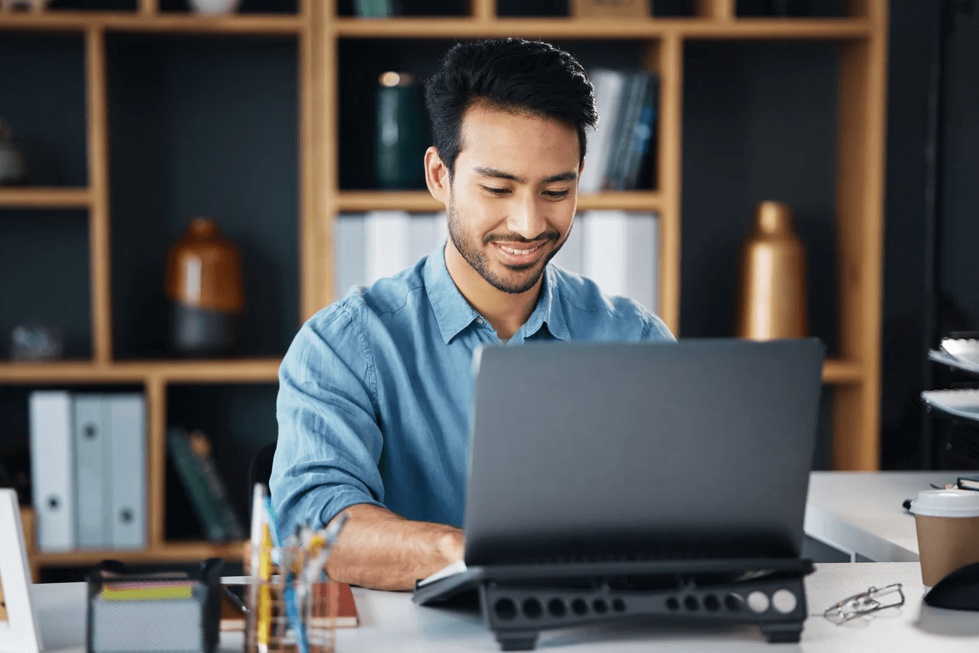 man sitting with his laptop smiling